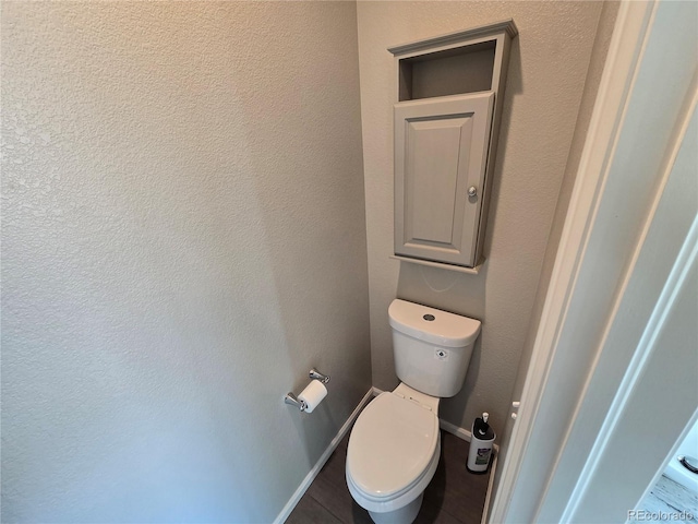 bathroom featuring baseboards and toilet