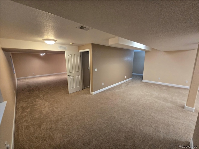 finished below grade area with carpet floors, visible vents, and baseboards