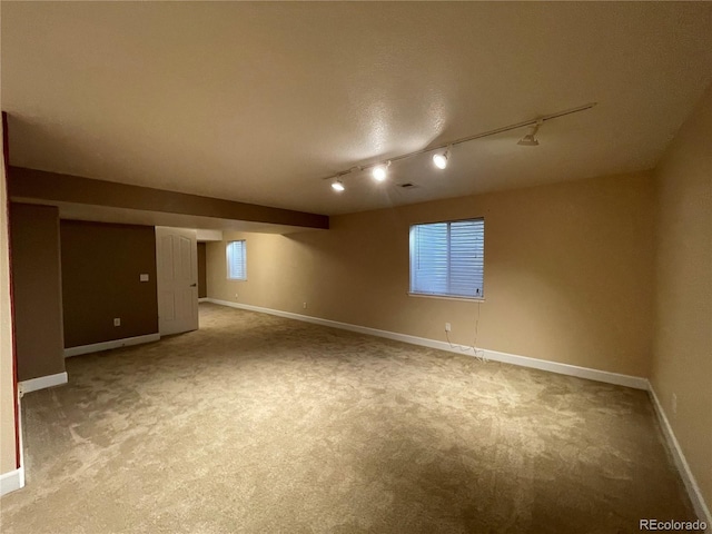 below grade area featuring light carpet and baseboards