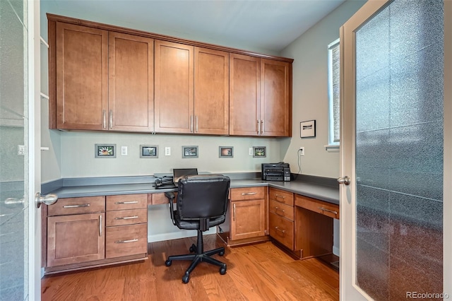 office area with built in desk and light hardwood / wood-style flooring