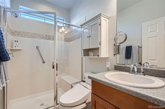 bathroom with vanity, a shower with shower door, and toilet