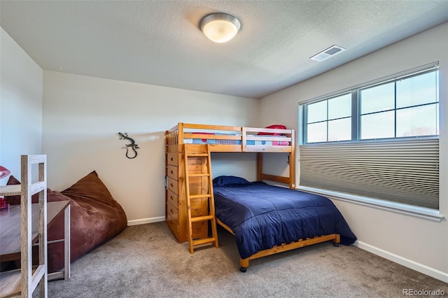 carpeted bedroom featuring a textured ceiling