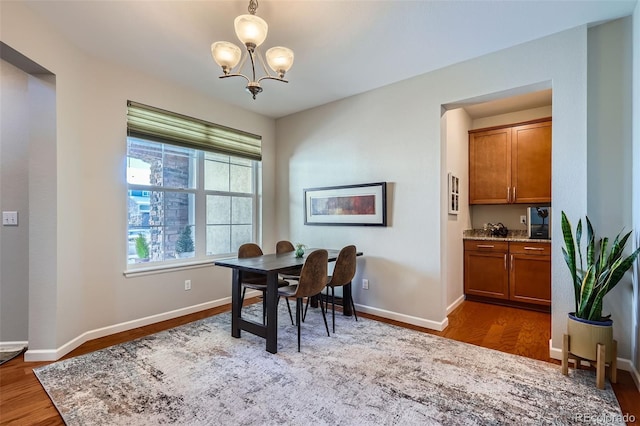 dining area featuring a notable chandelier and dark hardwood / wood-style flooring