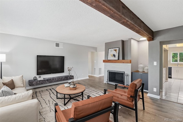2973 Mesa Rd Unit C, Colorado Springs, CO 80904 - living room with wood finished floors, a textured ceiling, a fireplace, and beam ceiling