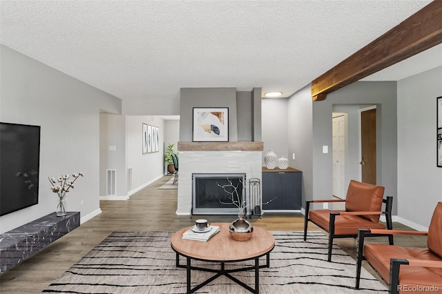 2973 Mesa Rd Unit C, Colorado Springs, CO 80904 - living room with a tiled fireplace, wood finished floors, and a textured ceiling