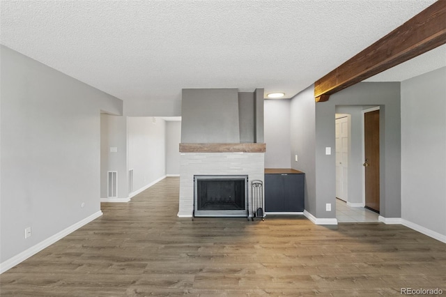 2973 Mesa Rd Unit C, Colorado Springs, CO 80904 - unfurnished living room with wood finished floors, a fireplace, and a textured ceiling