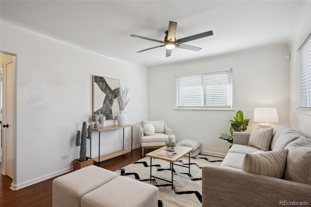 living area featuring ceiling fan, baseboards, and dark wood-type flooring