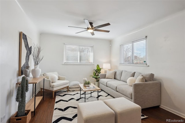 living area with dark wood-style floors, baseboards, and a ceiling fan