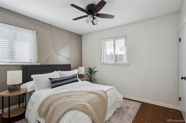 bedroom with ceiling fan, baseboards, and wood finished floors