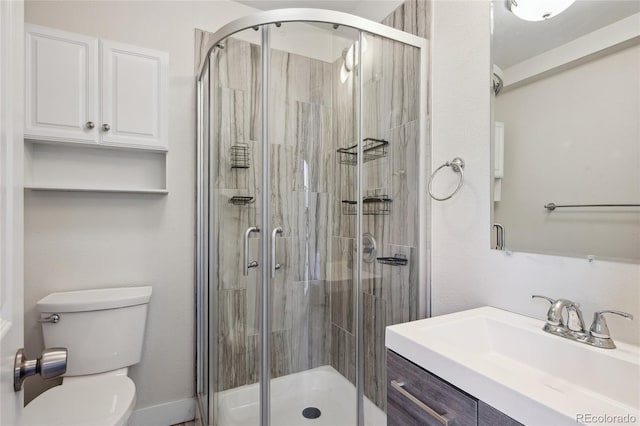 full bath featuring vanity, a shower stall, and toilet