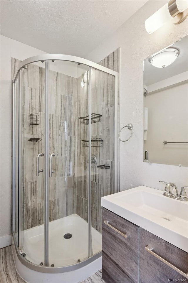 full bath featuring a stall shower and vanity