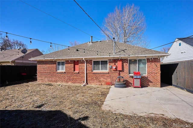 back of property featuring brick siding, a patio area, and fence