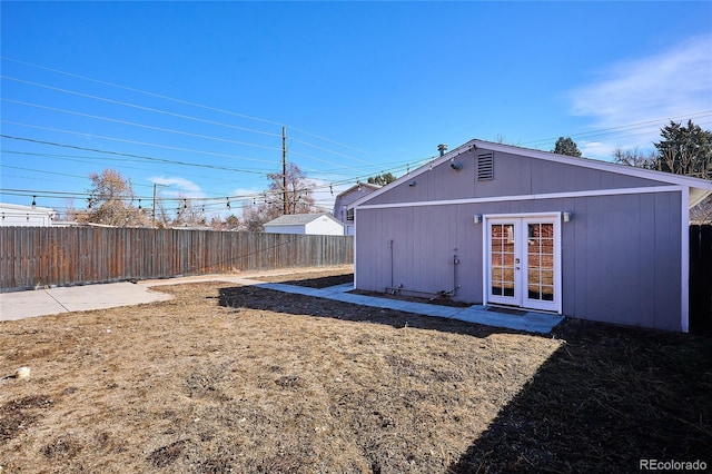 rear view of property featuring fence private yard, french doors, and a yard