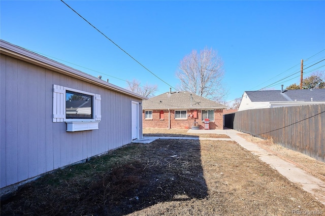 rear view of house featuring fence and a patio