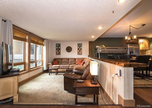 living room with a textured ceiling, dark hardwood / wood-style floors, and an inviting chandelier