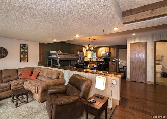 living room featuring a chandelier, a textured ceiling, and dark hardwood / wood-style floors