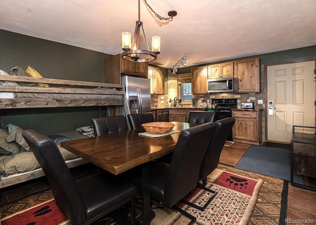 dining area featuring a notable chandelier, wood-type flooring, and sink