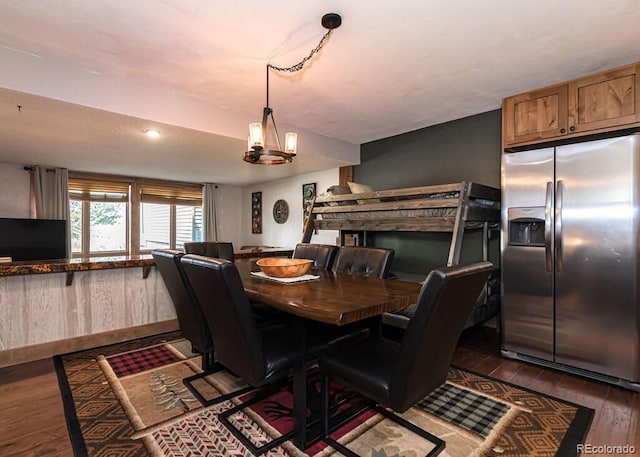 dining area with dark hardwood / wood-style floors and a chandelier