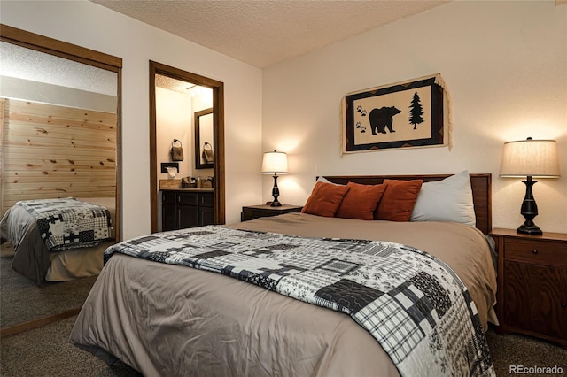 bedroom featuring carpet, a textured ceiling, and connected bathroom