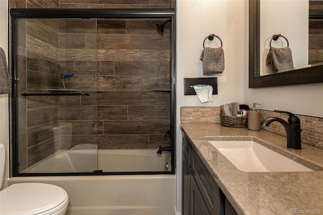 full bathroom with vanity, toilet, and shower / bath combination with glass door