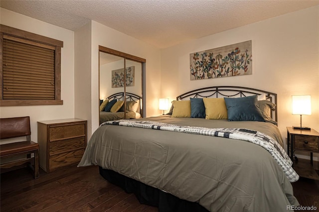 bedroom with a textured ceiling, dark wood-type flooring, and a closet