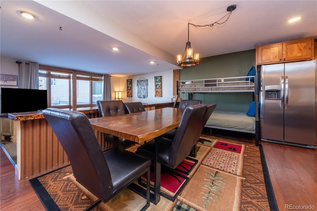 dining room with hardwood / wood-style floors and an inviting chandelier