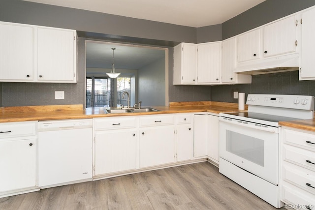 kitchen with light wood-type flooring, white appliances, sink, white cabinets, and hanging light fixtures