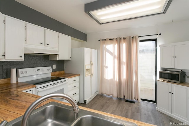 kitchen featuring white appliances, sink, decorative backsplash, light wood-type flooring, and white cabinetry