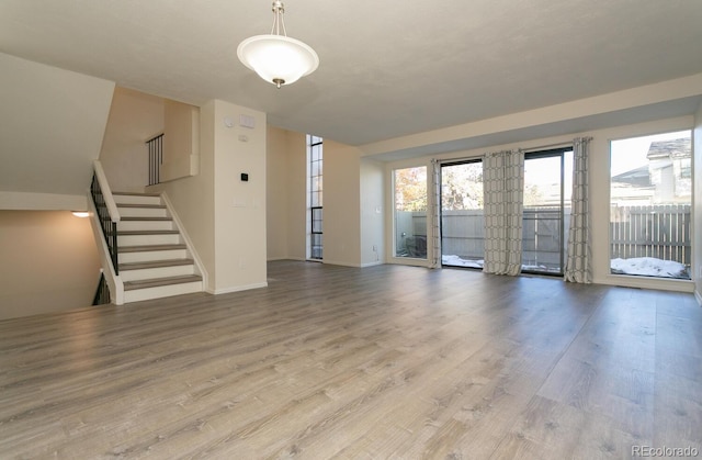 7900 W Layton Ave Unit 833, Littleton, CO 80123 - unfurnished living room with wood finished floors, baseboards, and stairway