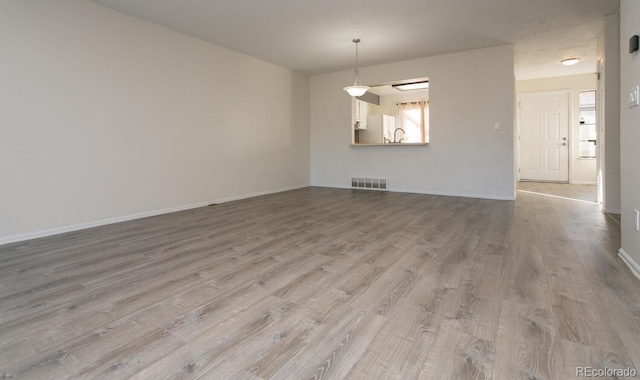 unfurnished room with light hardwood / wood-style floors and sink