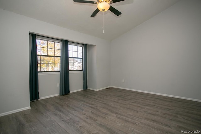 empty room with ceiling fan, dark hardwood / wood-style flooring, and vaulted ceiling