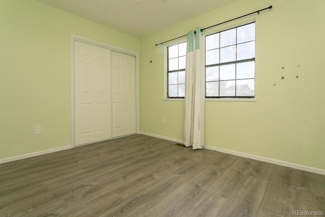 unfurnished bedroom featuring a closet and dark hardwood / wood-style floors