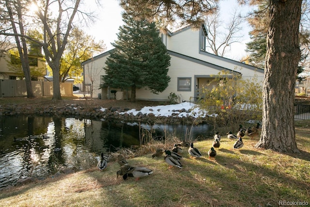 view of property exterior with a water view and a lawn