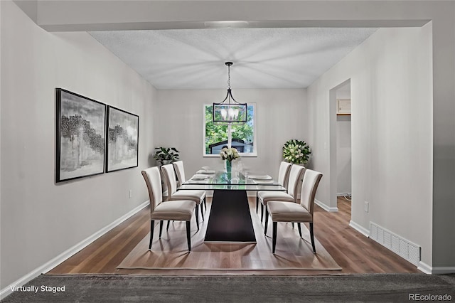 6240 W 110th Pl, Westminster, CO 80020 - dining room featuring wood finished floors, a chandelier, and a textured ceiling