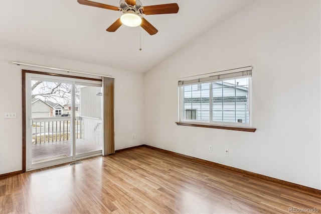 spare room featuring ceiling fan, lofted ceiling, a healthy amount of sunlight, and light hardwood / wood-style floors