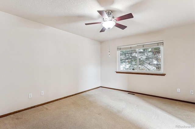 empty room featuring ceiling fan, carpet floors, and a textured ceiling