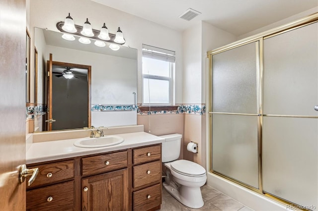 bathroom featuring vanity, toilet, an enclosed shower, and tile patterned flooring