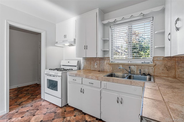 kitchen featuring white cabinets, ventilation hood, white gas stove, and sink