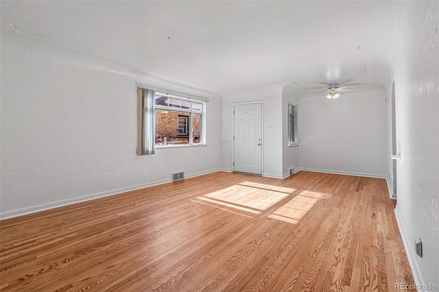 empty room with ceiling fan and light hardwood / wood-style floors