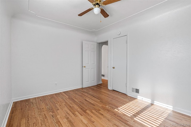 empty room with ceiling fan and light hardwood / wood-style flooring