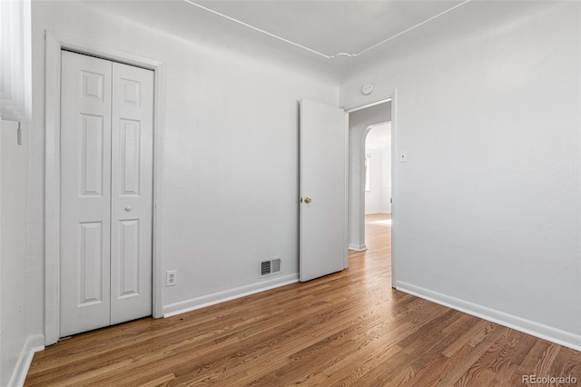 unfurnished bedroom featuring hardwood / wood-style floors and a closet