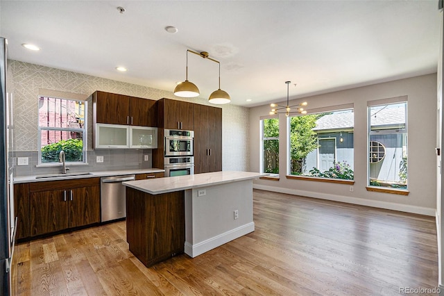 4258 Tennyson St Unit 101, Denver, CO 80212 - kitchen featuring appliances with stainless steel finishes, light countertops, light wood-type flooring, a center island, and recessed lighting