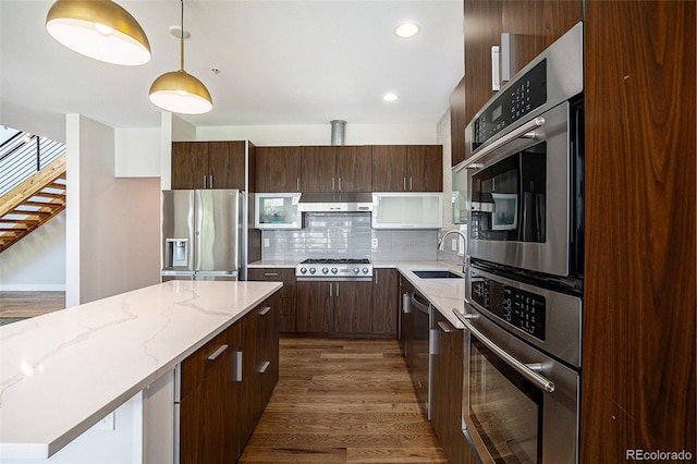 4258 Tennyson St Unit 101, Denver, CO 80212 - kitchen featuring stainless steel appliances, under cabinet range hood, backsplash, dark brown cabinetry, and recessed lighting
