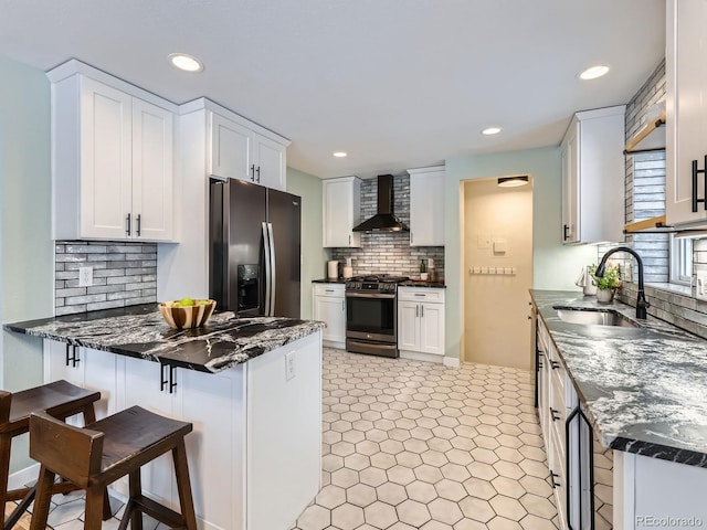 kitchen featuring white cabinetry, wall chimney range hood, sink, and appliances with stainless steel finishes