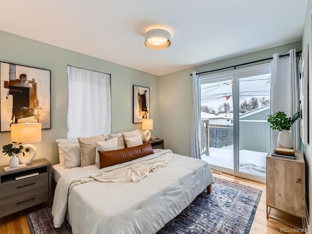 bedroom with access to exterior and light wood-type flooring