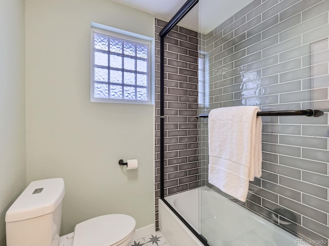 bathroom featuring shower / bath combination with glass door, tile patterned flooring, and toilet