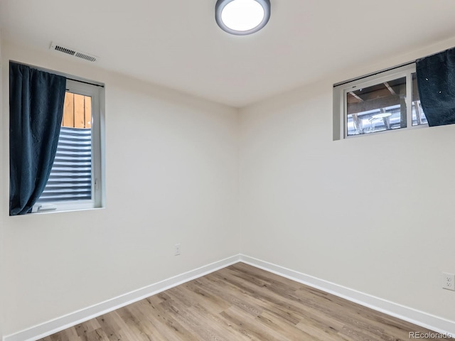 spare room with hardwood / wood-style floors and plenty of natural light