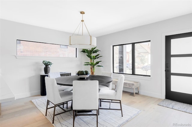 dining space featuring baseboards and light wood finished floors