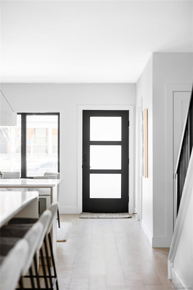 foyer entrance featuring baseboards and stairs