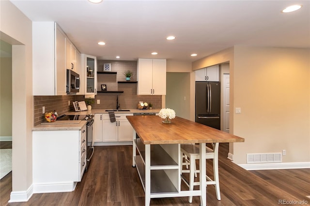 8160 W Phillips Ave, Littleton, CO 80128 - kitchen featuring butcher block countertops, open shelves, freestanding refrigerator, recessed lighting, and stainless steel microwave